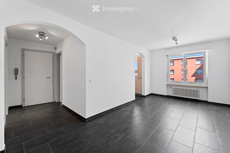empty room, black tiles, white walls, white door, window with white shutter, white radiator