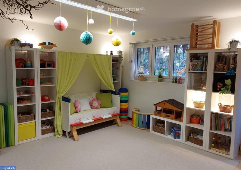 Brightly colored children's room with a small sofa under a green curtain, bookshelves filled with toys and books, a toy house, and colorful storage items.