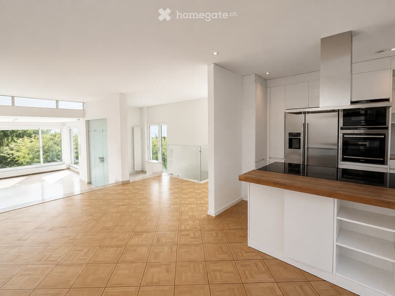 Modern kitchen with white cabinets, stainless steel appliances, wooden countertop, and large windows overlooking greenery.