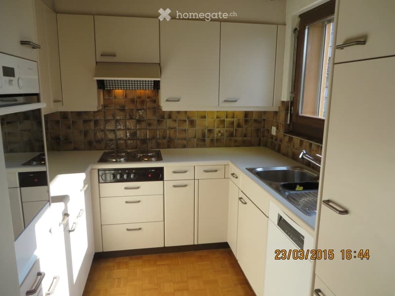 Modern kitchen with white cabinets, stainless steel appliances, and a tiled backsplash. Features an oven, stove, sink, and faucet.