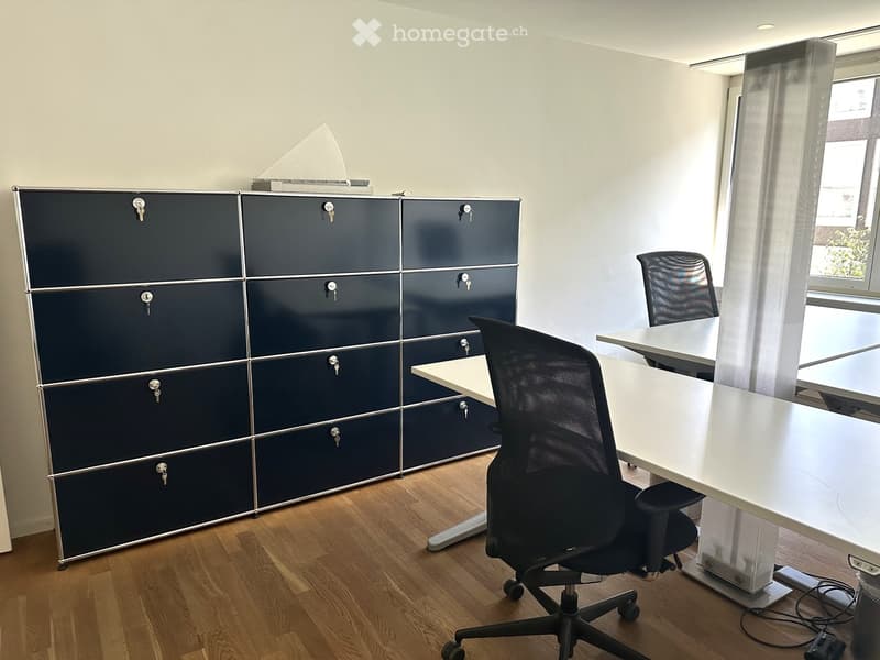 Office space with a dark blue cabinet, white table, and black office chair.