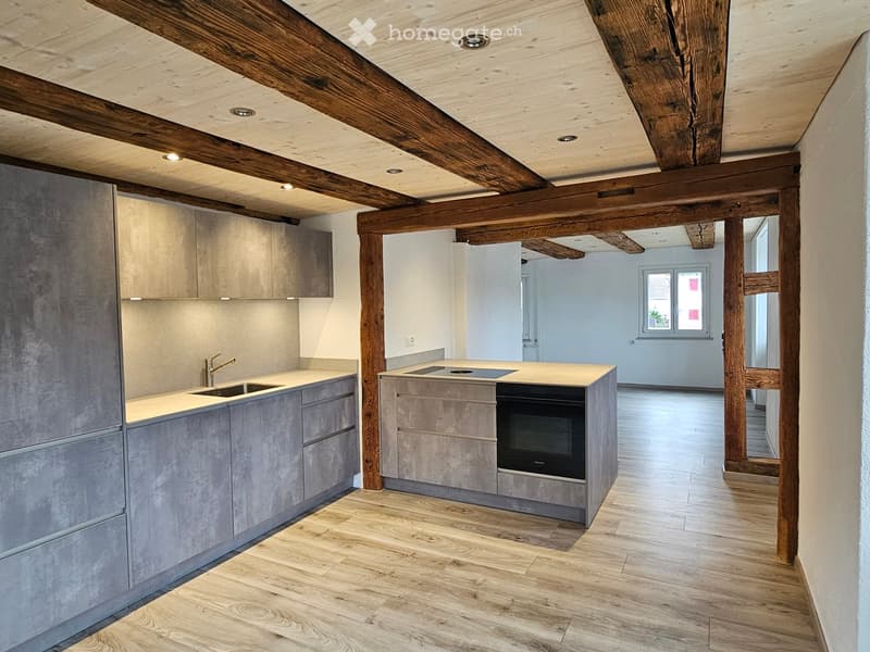modern kitchen with island, wooden beams, open floor plan, modern appliances, white ceiling, wooden flooring