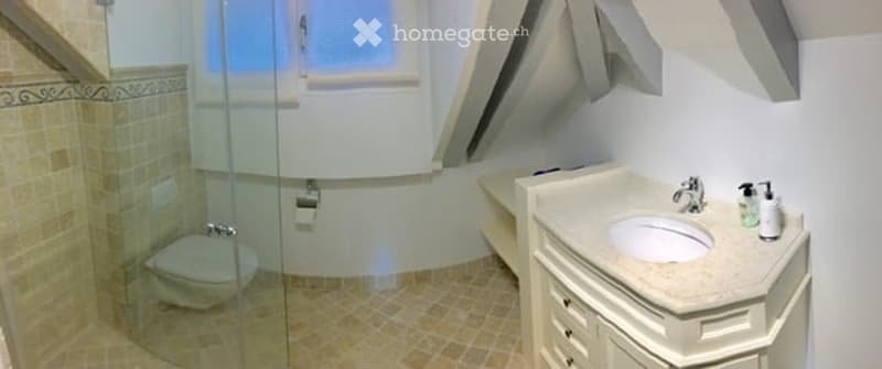 Modern bathroom with a glass-enclosed shower, a bathtub, a toilet, a sink with a faucet, and a cabinet with a soap dispenser.