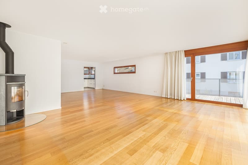 Empty room with hardwood floors, white walls, a fireplace, and a glass door leading to a balcony.