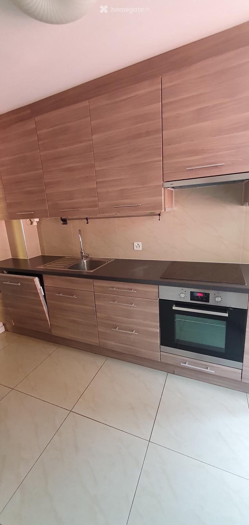 Modern kitchen with wooden cabinets, stainless steel oven, sink, and countertop.