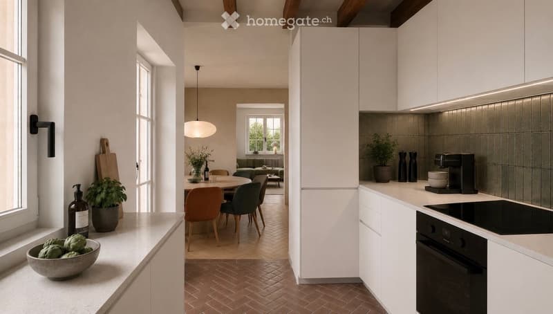 Modern kitchen with white cabinets, a central island, and a dining area visible through an open doorway. The kitchen features a built-in oven, coffee maker, and various decorative items including a potted plant and a bowl of vegetables on the counter.