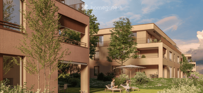 Modern multi-story residential building with balconies, surrounded by a landscaped garden with lounge chairs, umbrella, and greenery.