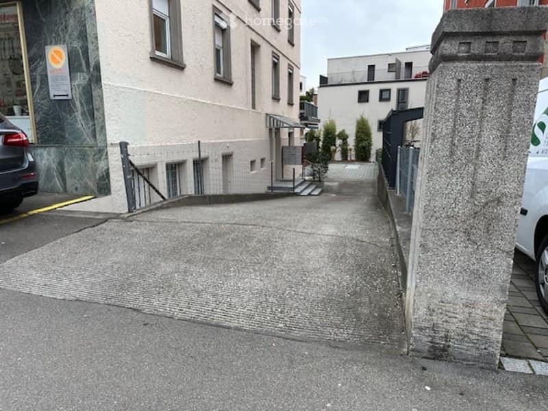 A raised ground floor entrance leading to a building with multiple windows and a small staircase.