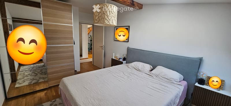 Modern bedroom with a large bed, nightstand, mirror, wardrobe, and decorative lamp.