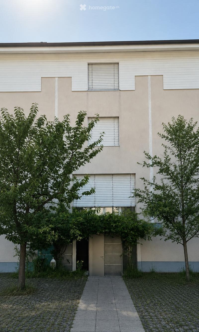 Modern single-story building with light beige facade, multiple windows with white blinds, and a central entrance door surrounded by greenery and trees.