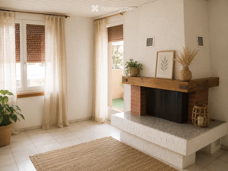 Modern living room with a brick fireplace, wooden mantel, and decorative items including a picture frame, vase, and plants. Large windows with blinds and sheer curtains allow natural light to fill the space.