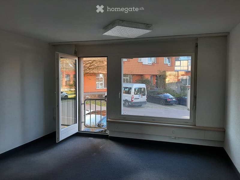 empty room, white walls, black floor, glass door, glass windows, metal railing, cars parked outside