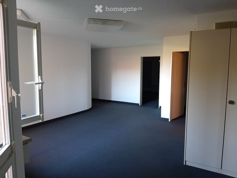 Empty room with white walls, blue carpet, glass door, and two doors leading to other rooms