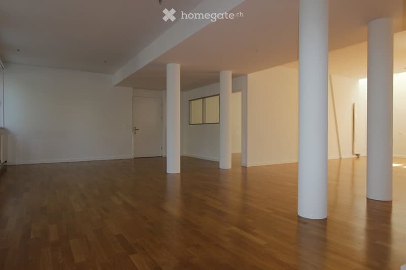 Empty room with wooden flooring, white walls, and white columns. No furniture or equipment present.