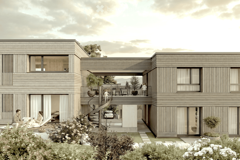 Modern two-story house with wooden siding, large windows, and a spacious balcony area. The ground floor features a lounge area with lounge chairs and a small garden, while the upper level includes a balcony with outdoor seating and a view of the surroundi