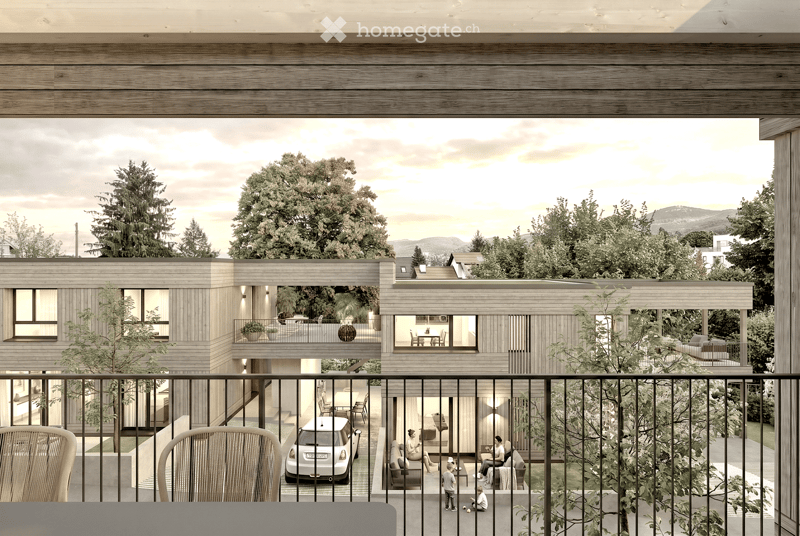 Modern two-story wooden house with large windows, balconies, and outdoor seating areas. The house features a contemporary design with a flat roof and is surrounded by trees and greenery. A car is parked in the driveway, and there are visible balconies wit