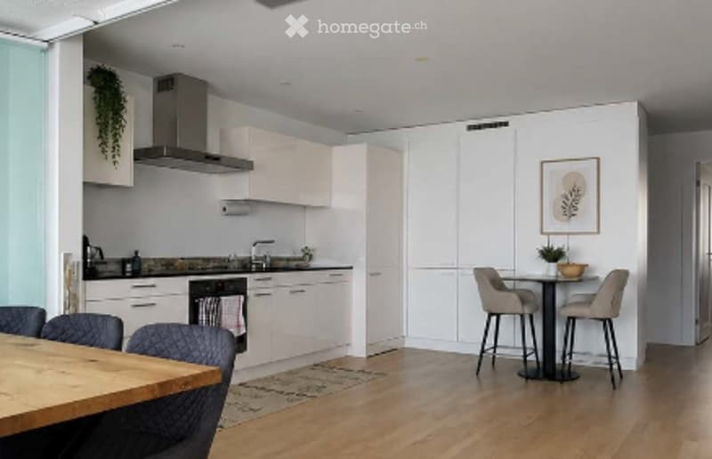 Modern kitchen with white cabinets, stainless steel appliances, island, and bar seating area.