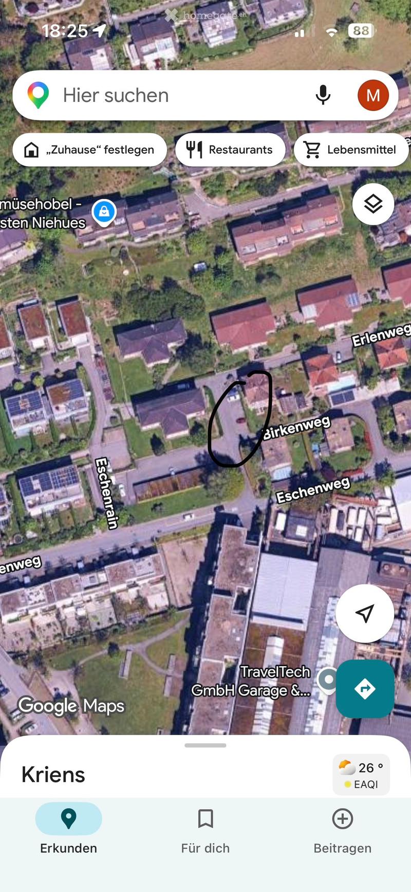 Aerial view of a residential area with multiple houses, roads, and greenery.