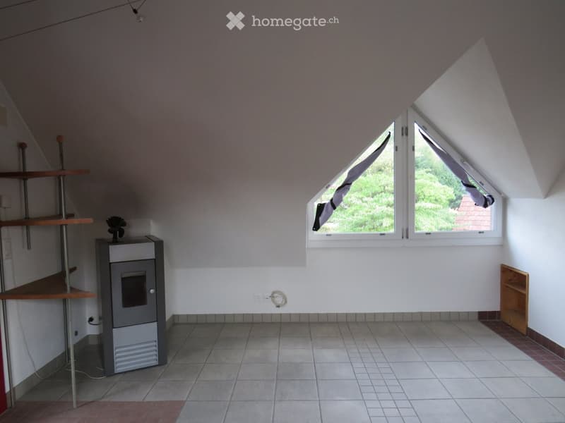 Loft-style room with slanted ceilings, tiled floor, and large windows. Includes a wooden shelf, a wooden cabinet, and a small wooden shelf.