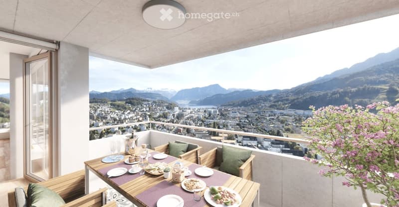 Balcony with a scenic mountain view, featuring a wooden table set for dining, chairs, and a small potted plant.