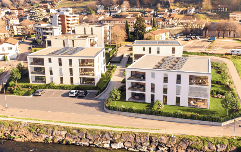 modern apartment buildings, multiple solar panels, parking lot, river nearby