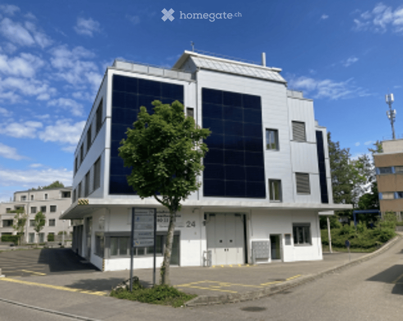 modern building, white exterior, large solar panels, ground floor parking area