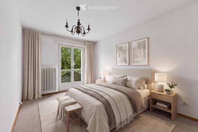 Modern bedroom with a large bed, nightstands, lamps, a wooden stool, framed artwork, and a chandelier. The room features large windows with curtains and a radiator.