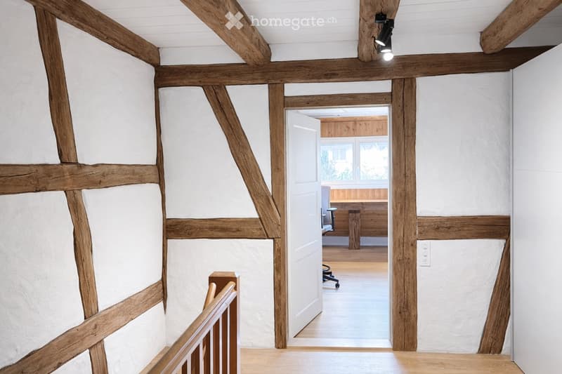 wooden beams, white walls, wooden floor, open door, office desk, chair, window