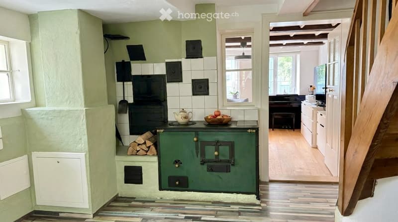 green wall, fireplace, white tiles, wooden floor, green oven, wooden stairs