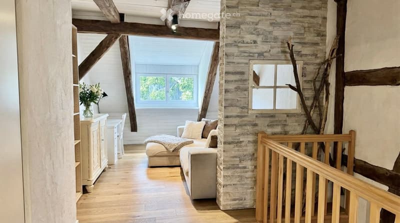 wooden beams, wooden floor, white walls, couch, window, cabinet, flowers