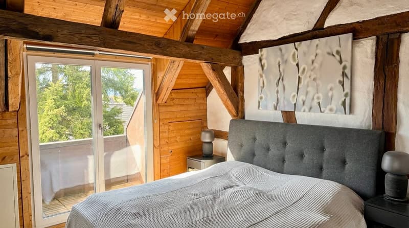 wooden walls, bed, bedside tables, lamps, large window, balcony, view of trees