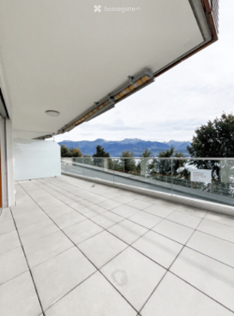 Balcony / Terrace. Modern balcony with white tiled floor, glass railing, and scenic mountain view.