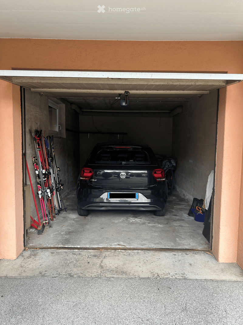 {"type": "Garage", "objects": [], "visible_features": ["Garage"], "description": "Underground garage with a parked car, skis, and other stored items."}