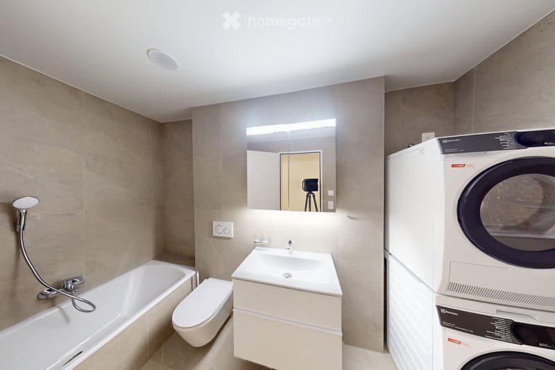 Bathtub, toilet, sink, washing machine, dryer, mirror, tiled walls