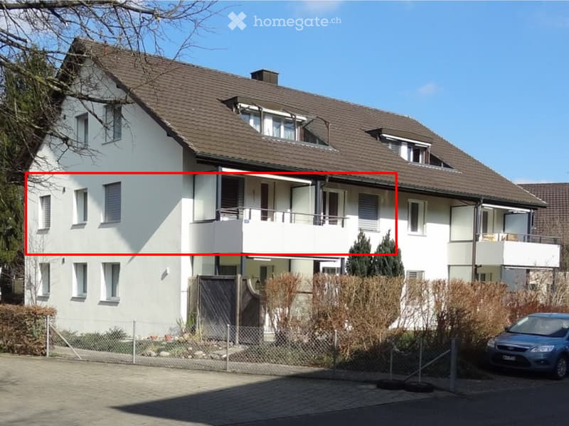 Two-story house with white exterior, brown tiled roof, multiple windows, and balconies on the upper level.