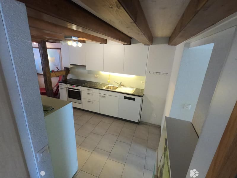 Modern kitchen with white cabinets, stainless steel appliances, and a tiled floor.