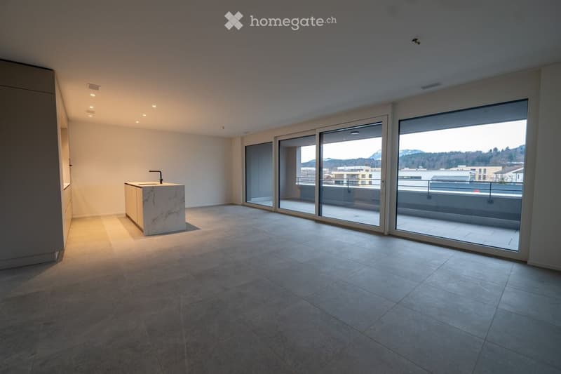 Empty room with tiled floor, white walls, and large sliding glass doors leading to a balcony. A small sink and cabinet are visible on the left side.