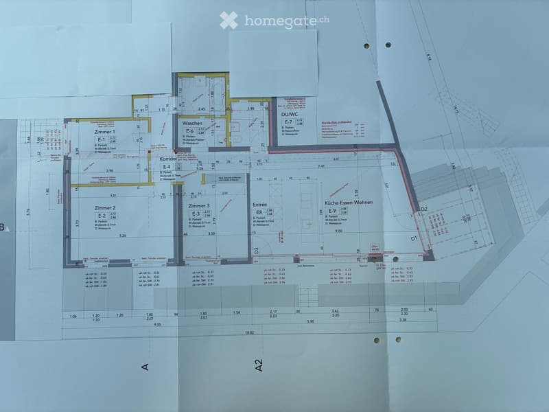 Floor plan of a residential building showing multiple rooms including a kitchen-dining-living area, three bedrooms, a corridor, a bathroom, and an entrance area.