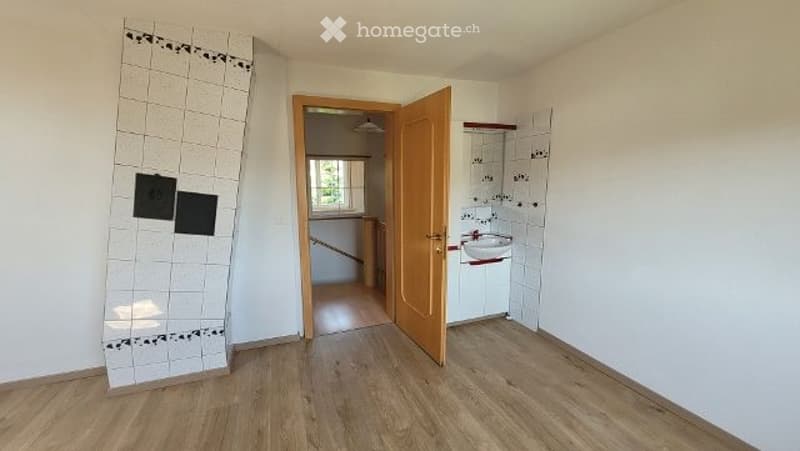 Empty room with wooden flooring, white walls, and an open doorway leading to another room. No furniture or equipment is present.