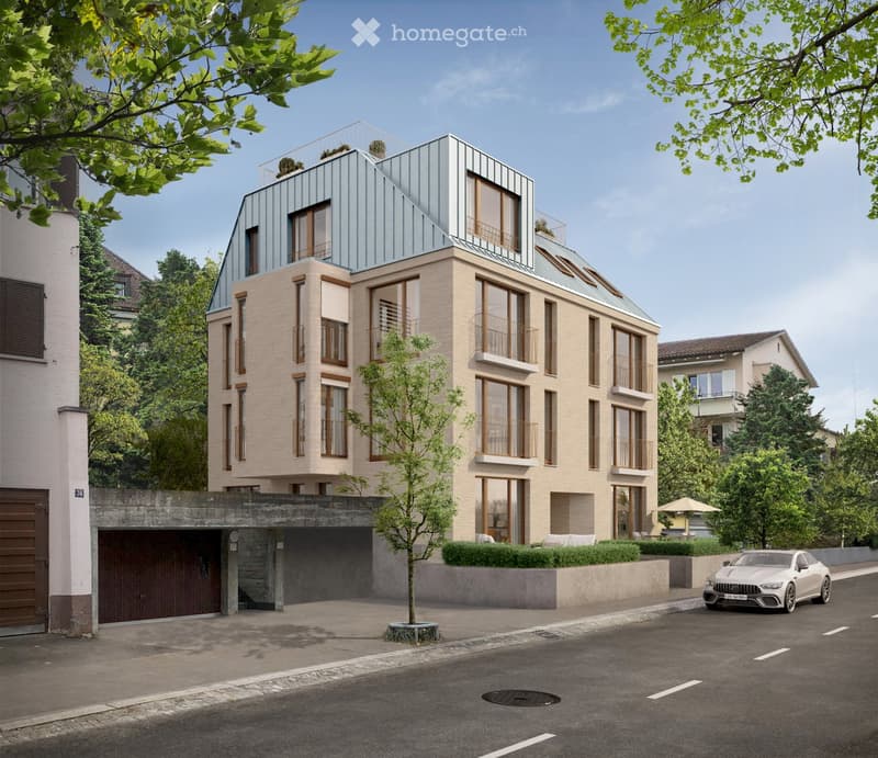 Modern multi-story building with beige facade, large windows, balconies, and a rooftop terrace. Features a covered garage entrance and a small tree in front.