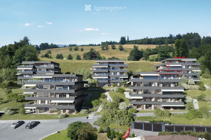 A modern multi-story residential complex with multiple apartments, balconies, and parking areas, situated on a hillside with surrounding greenery and a clear view of the landscape.
