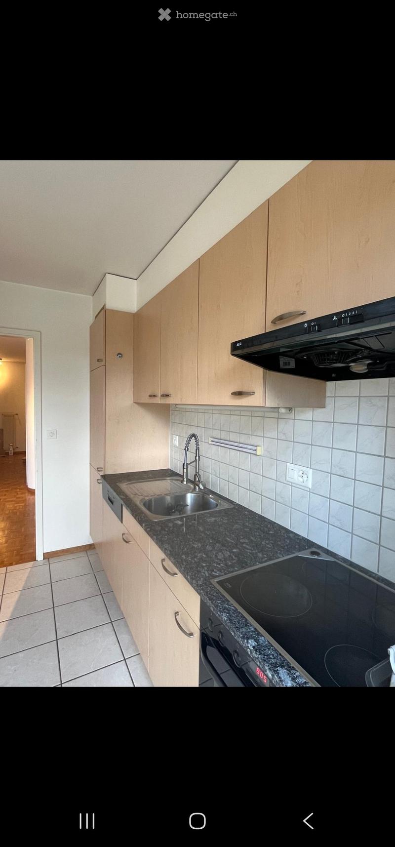 Modern kitchen with light wooden cabinets, granite countertop, stainless steel sink, electric stove, and range hood.