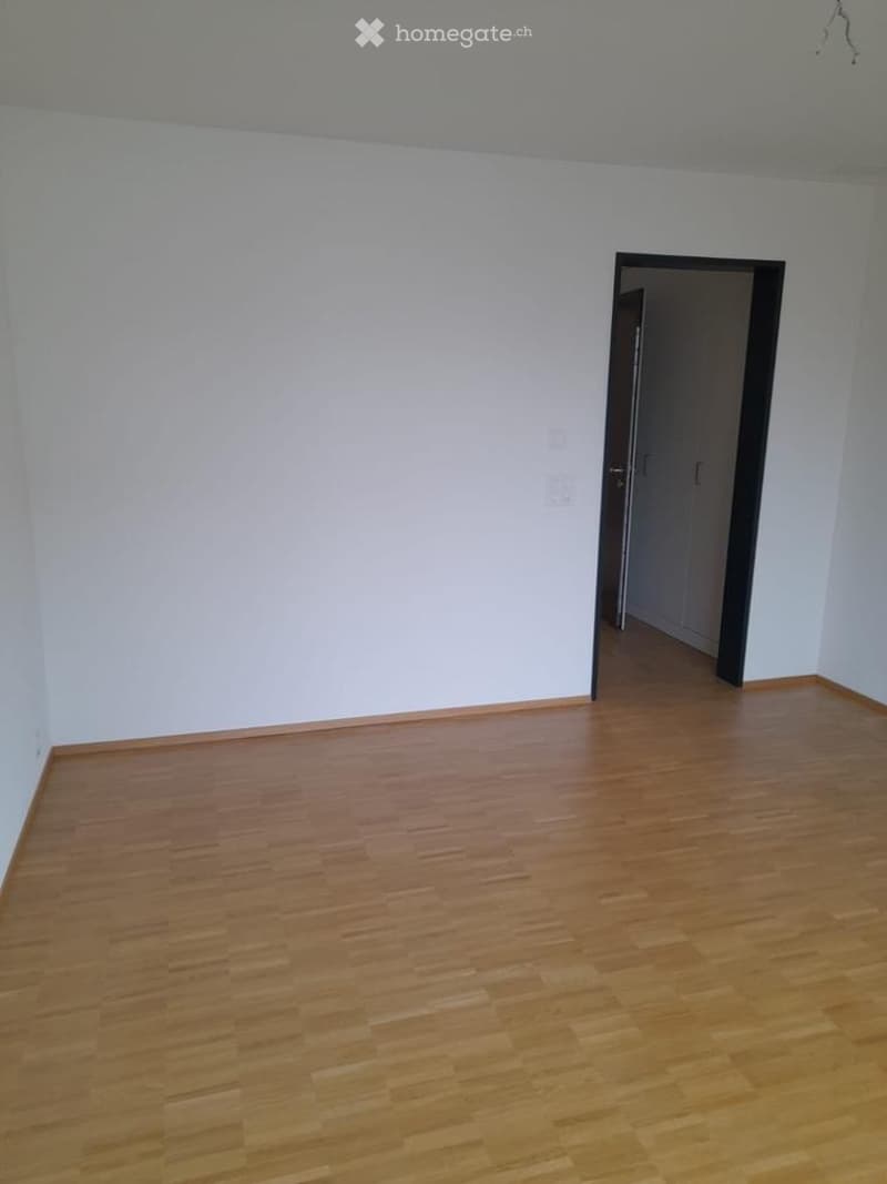 Completely empty room with bare white walls and wooden floor. No furniture or equipment.
