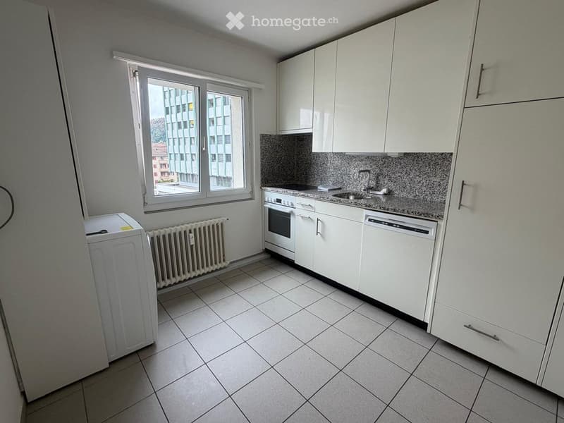 Modern kitchen with white cabinets, tiled floor, granite countertop, and stainless steel appliances including an oven, dishwasher, and sink.