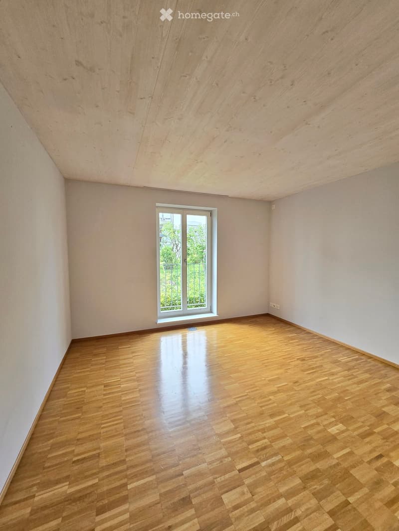 empty room with wood floors, white walls, one window, high ceiling