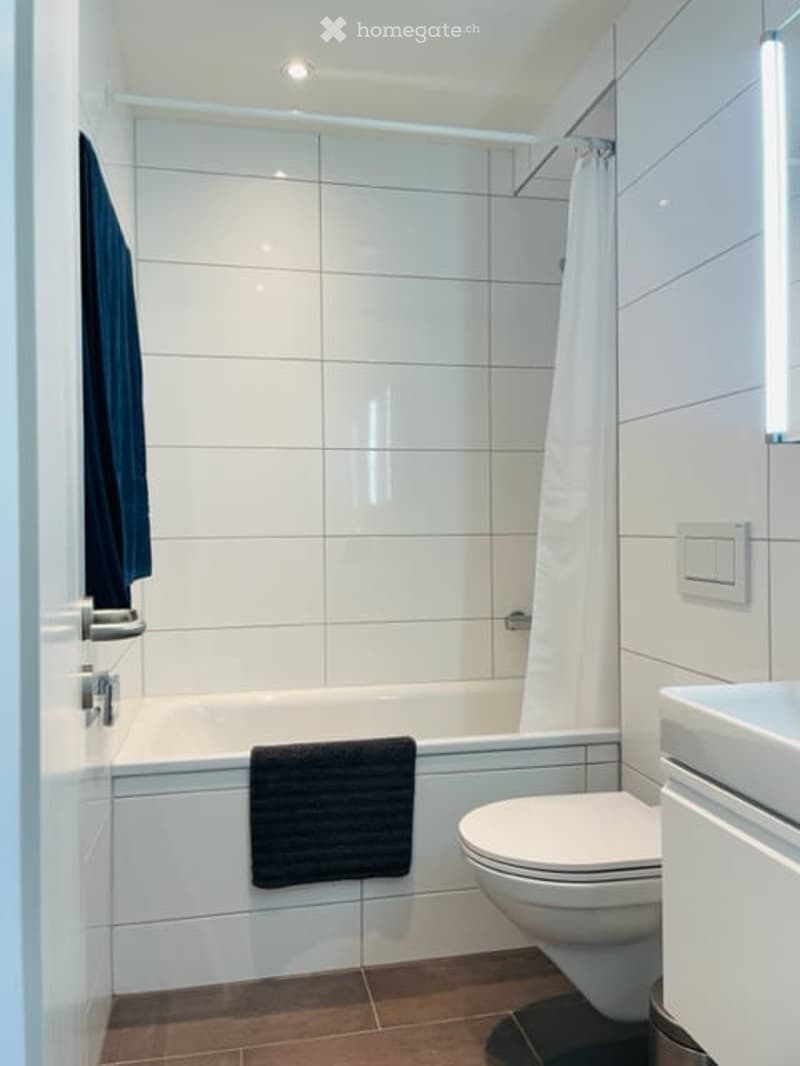 white tiles, bathtub, shower, white sink, white toilet, towel