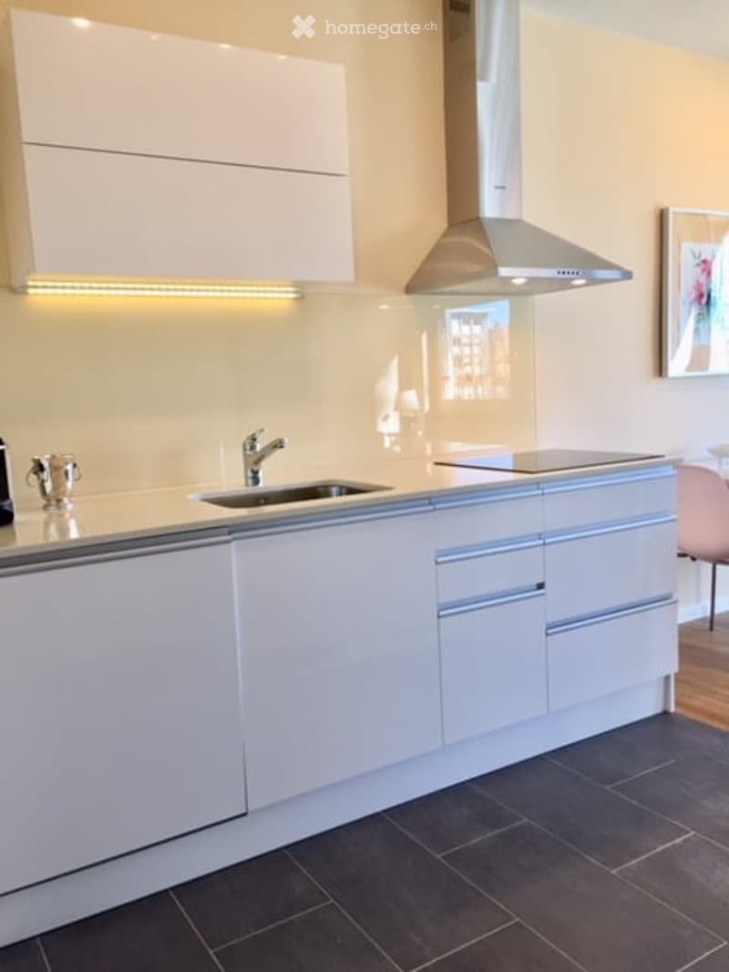 modern white kitchen with a sink, gas range, and cabinets