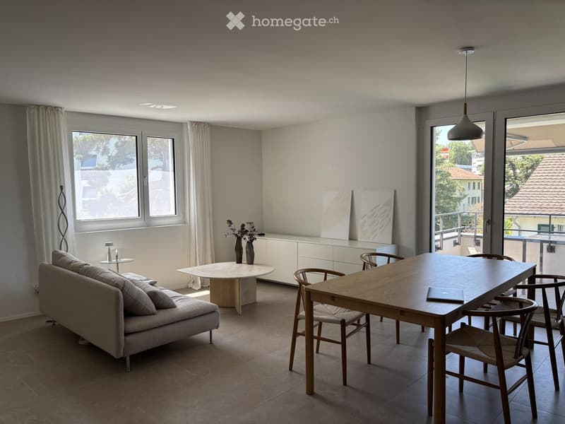 Modern living and dining area with a sofa, coffee table, dining table, chairs, and decorative vases.
