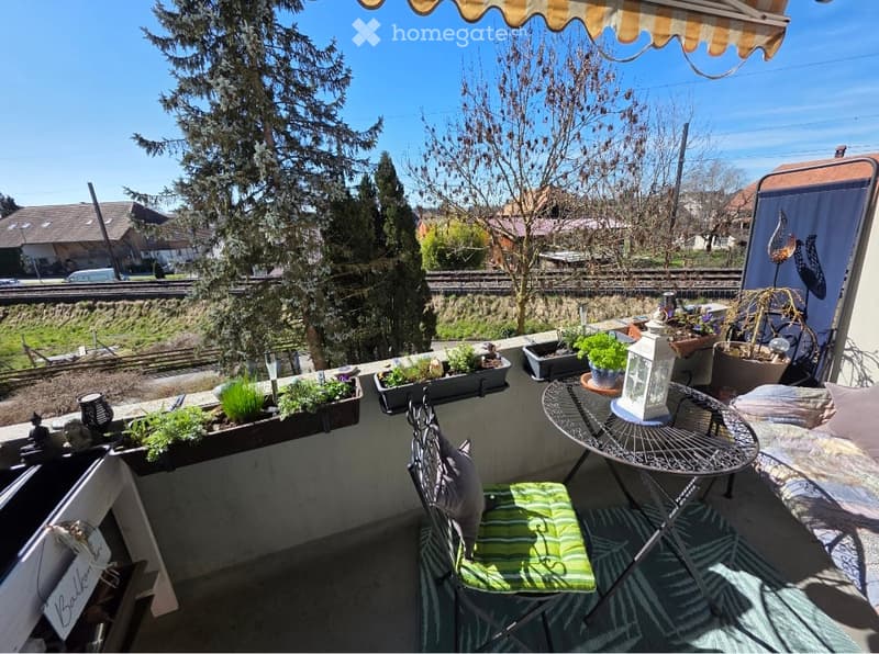 Balcony with outdoor furniture, potted plants, and a view of the surrounding area.
