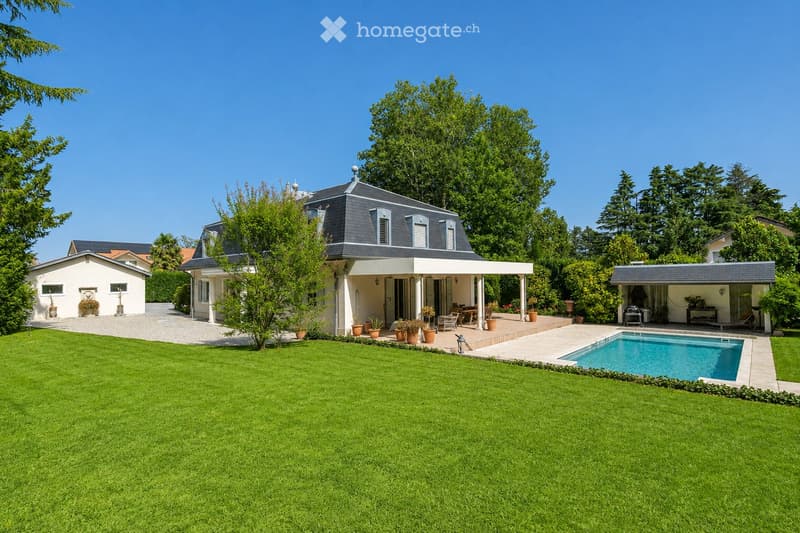 Well-maintained garden with a swimming pool, patio, outdoor furniture, and several potted plants.